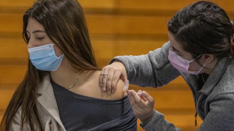 一名骨科医学院的学生在疫苗诊所给另一名学生注射疫苗